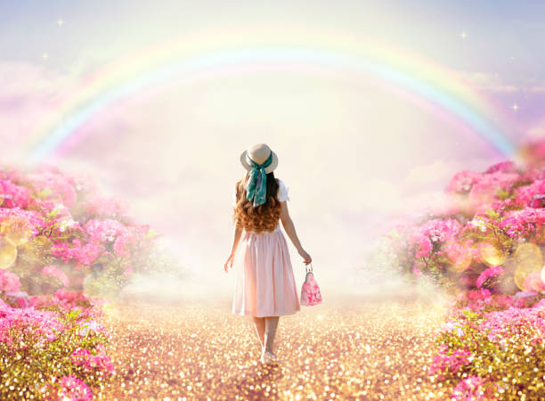 Lady woman in romantic pink dress and retro hat walking along rose garden path leading to fabulous rainbow unicorn house, flecks of sunlight on road. Tranquil fantasy scene, fairytale hills. Young lady woman in romantic pink dress, retro hat, bag walking along rose garden path leading to fabulous rainbow unicorn house, flecks of sunlight on road. Tranquil fantasy scene, fairytale hills. walking loneliness one person journey stock pictures, royalty-free photos & images