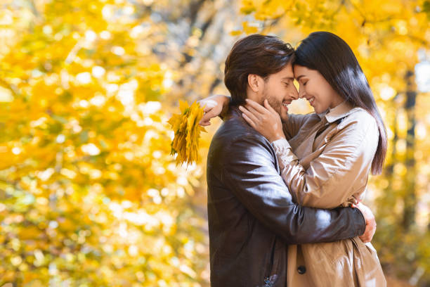 istock Loving man and woman cuddling while walking by golden forest 1281675619