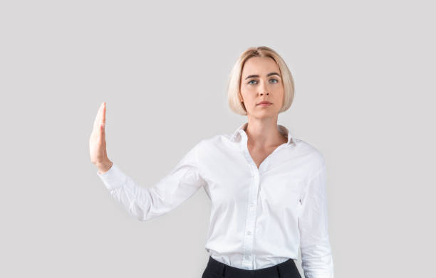 istock Confident mature business lady gesturing STOP on light grey studio background 1281675872