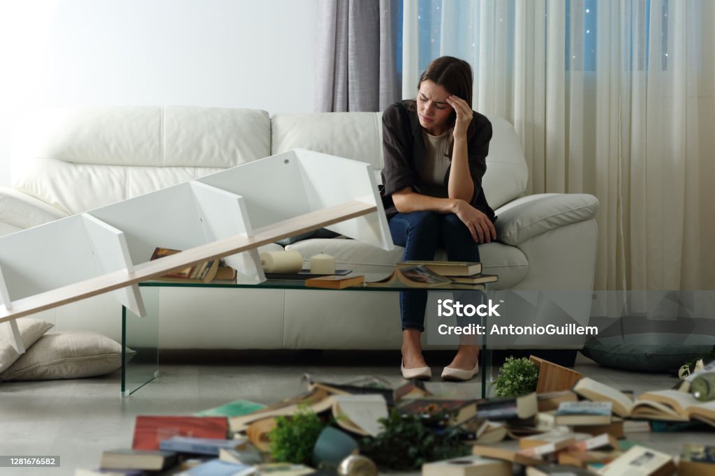 Sad tenant complaining after home robbery in the night Burglary Stock Photo