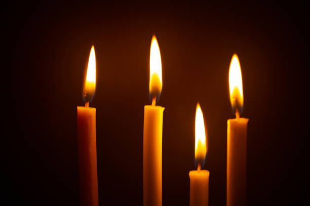 Group of still life golden candle light with reflection on soft red blurred background. Abstract background for pray or meditation caption and hope concept.