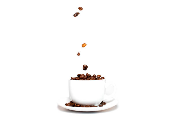 istock Roasted coffee beans falling into a coffee cup on a saucer with a white background, close-up, coffee wallpaper 1281679336