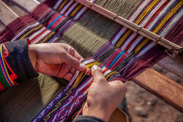 Peruvian woman weaving, The Sacred Valley, Chinchero The Sacred Valley of the Incas or Urubamba Valley is a valley in the Andes  of Peru, close to the Inca capital of Cusco and below the ancient sacred city of Machu Picchu. The valley is generally understood to include everything between Pisac  and Ollantaytambo, parallel to the Urubamba River, or Vilcanota River or Wilcamayu, as this Sacred river is called when passing through the valley. It is fed by numerous rivers which descend through adjoining valleys and gorges, and contains numerous archaeological remains and villages. The valley was appreciated by the Incas due to its special geographical and climatic qualities. It was one of the empire's main points for the extraction of natural wealth, and the best place for maize production in Peru.http://bem.2be.pl/IS/peru_380.jpg peruvian culture stock pictures, royalty-free photos & images