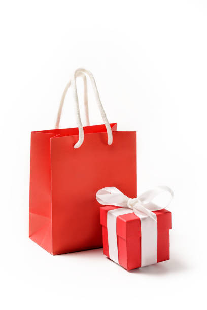 istock Red paper bag and red box with a bow on a white background. 1281681309