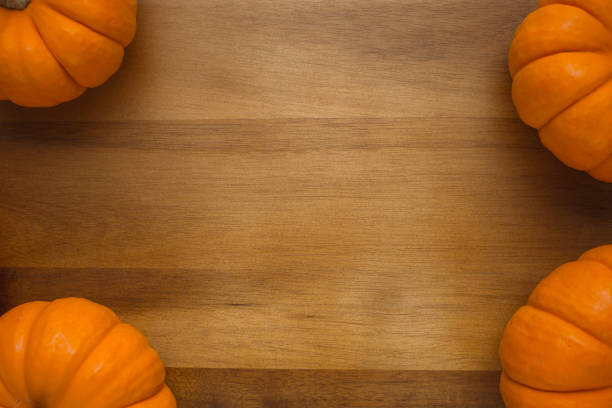 istock Beautiful orange mini pumpkins on wood board 1281681440