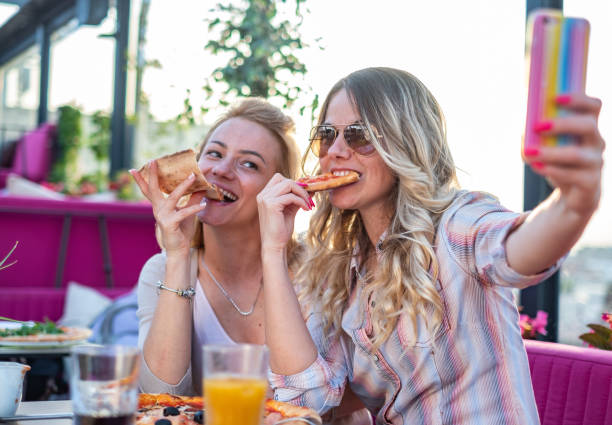 istock Women eating pizza 1281681637