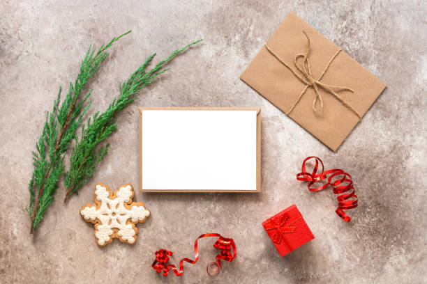 istock Christmas composition. Blank card mockup, fir branches, gift box, letter in craft envelope, gingerbread snowflake. Christmas card template. Top view, flat lay. 1281684206