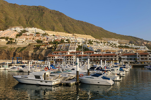 Marine port for yacht, motorboat, sailboat parking service facility and moorings for luxury and wealthy millionaire in aerial view with many ships anchoring along the dock bay