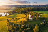 Church on the hill with sunlit summer landscape from above. Aerial view of Bysicky
