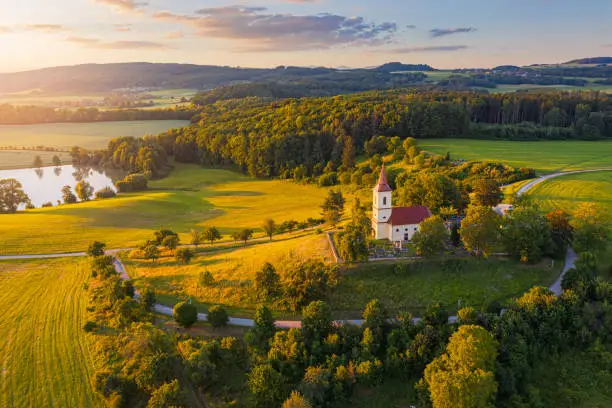 Photo of Church on the hill with sunlit summer landscape from above. Aerial view of Bysicky