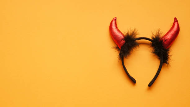 istock Red devil horns head hoop on orang background. Accessory for Halloween celebration, top view, flat lay, copy space 1281688652