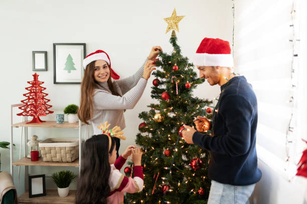 istock Woman decorating tree with family 1281689354