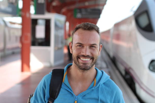 istock Blonde man smiling in train station 1281690580