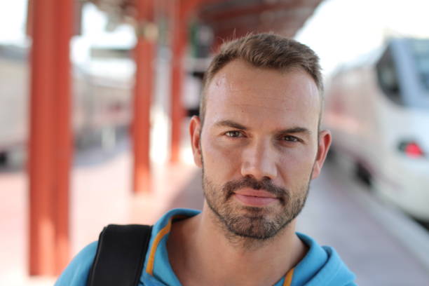 istock Blonde man smiling in train station 1281690640
