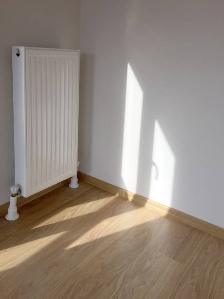 istock New modern home radiator with clean wall and parquet flooring, home interior 1281692001