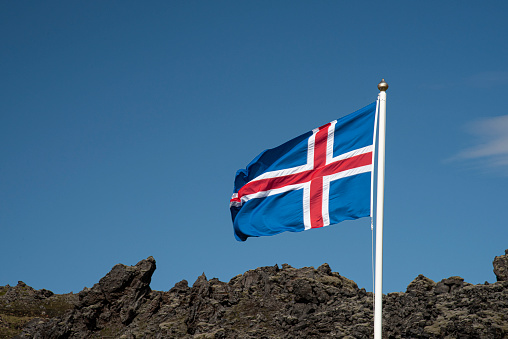 Des drapeaux norvégiens à côté d’un lac avec des montagnes, à Svartisen, en Norvège