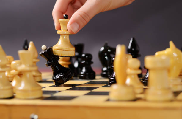 istock Playing chess. White queen Hitting the black one in front of the rest figures 1281692733