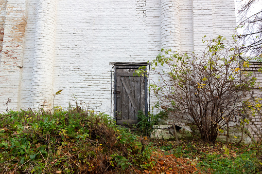 old church wall and back door in october day