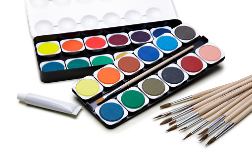 Watercolor paints box with paint brush on white background.