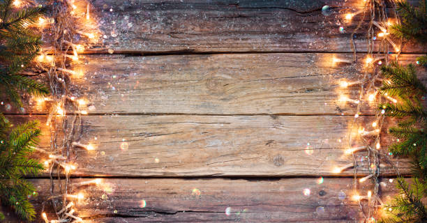Fir Branches And String Light On Old Wooden Plank Merry Christmas - Natural Wooden With Green Spruce And Lights christmas card photos stock pictures, royalty-free photos & images