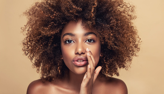 Joven mujer de piel marrón está compartiendo nuevos secretos con nosotros. Cabello afro natural y denso en la cabeza de joven modelo hermoso. photo