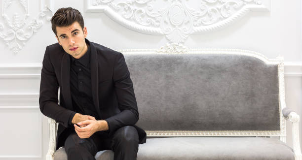 istock Elegant young man wearing suit sitting in classic workplace. 1281698474