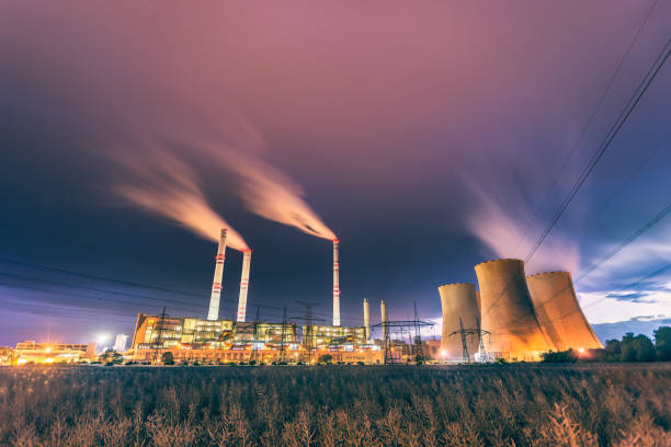 istock Coal power plant with chimneys and cooling towers during evening 1281699667