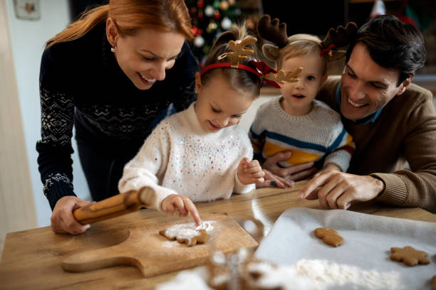 istock Happy family having fun while preparing gingerbread cookies for Christmas. 1281704081