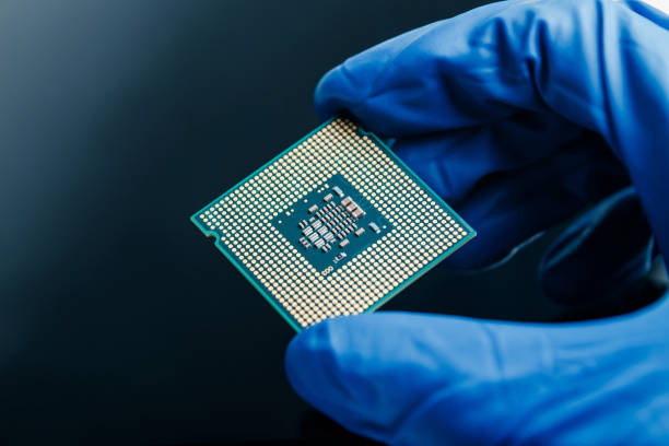 istock Close-up view on a new semiconductor microchip in gloved hand of computer scientist. Modern technology and hardware development 1281705352