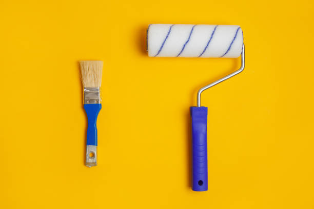 istock Paint roller and brush isolated on yellow. Painter tools for working with paint. 1281705356