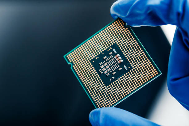 istock Close-up view on a new semiconductor microchip in gloved hand of computer scientist. Modern technology and hardware development 1281705365