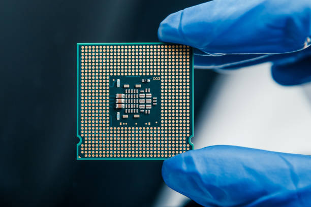 istock Close-up view on a new semiconductor microchip in gloved hand of computer scientist. Modern technology and hardware development 1281705366