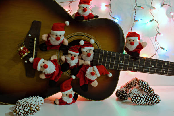 group portrait of funny santa claus toys on the background of old acoustic guitar