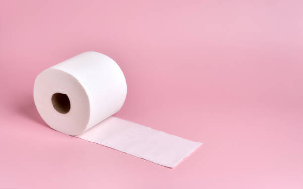istock roll of white toilet paper, slightly unrolled, on a plain pink background 1281711569