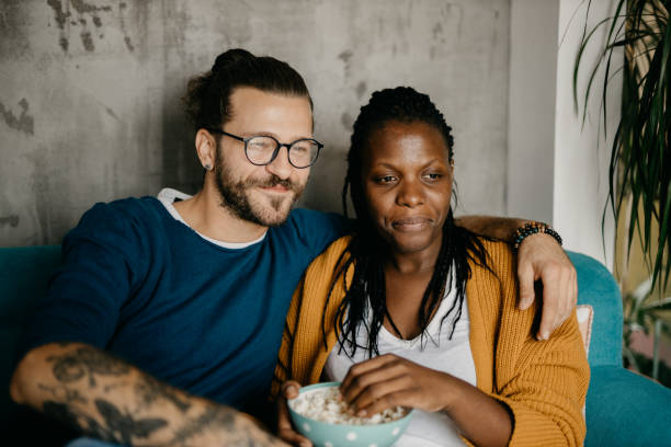 istock Couple relaxing on the couch at home watching TV 1281713325