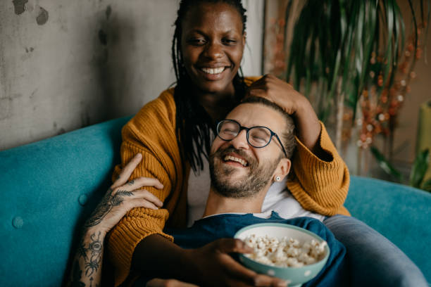 istock Couple relaxing on the couch at home watching TV 1281713399