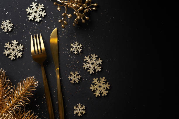 Christmas golden deco on dark Christmas golden cutlery with snowflake on dark background. restaurant table card stock pictures, royalty-free photos & images