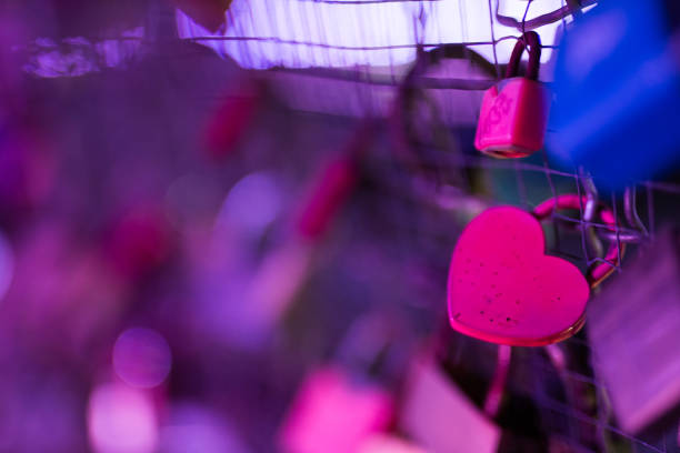 Padlock on footbridge in Krakow. Night. Close shot. No people. Lights in background.