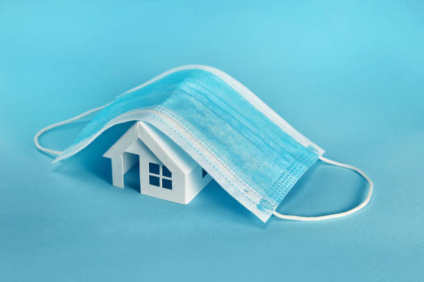 istock Paper house model cover by a mask isolated on blue background 1281720065