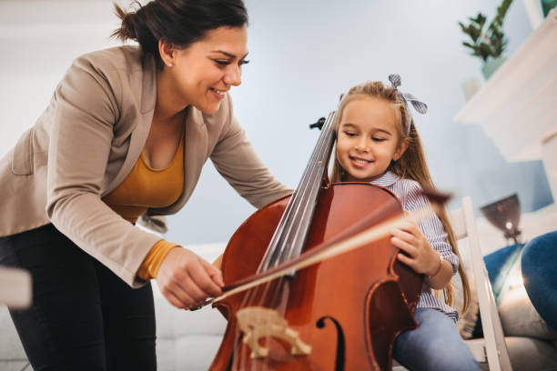 garotinha aprendendo a jogar violoncelo - sheet music music classroom education - fotografias e filmes do acervo