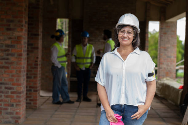 istock Chief engineer in the foreground looking at the camera with her goggles and protective vest on 1281721342