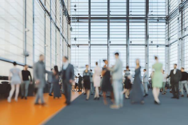 Blurred motion of young male business professionals on the move through lobby of modern corporate office.