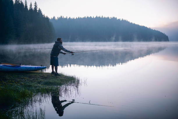 Man fishing on the mountain river at evening.
