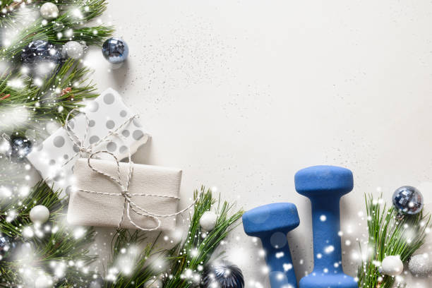 istock Christmas composition with blue dumbbells, gift, fir branches on white. Copy space. Xmas greeting card. 1281726872