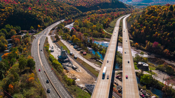 vue aérienne de l’usine de béton à proximité du pont élevé au-dessus de la rivière lehigh à la pennsylvania turnpike par une journée ensoleillée à l’automne. - rapid appalachian mountains autumn water photos et images de collection