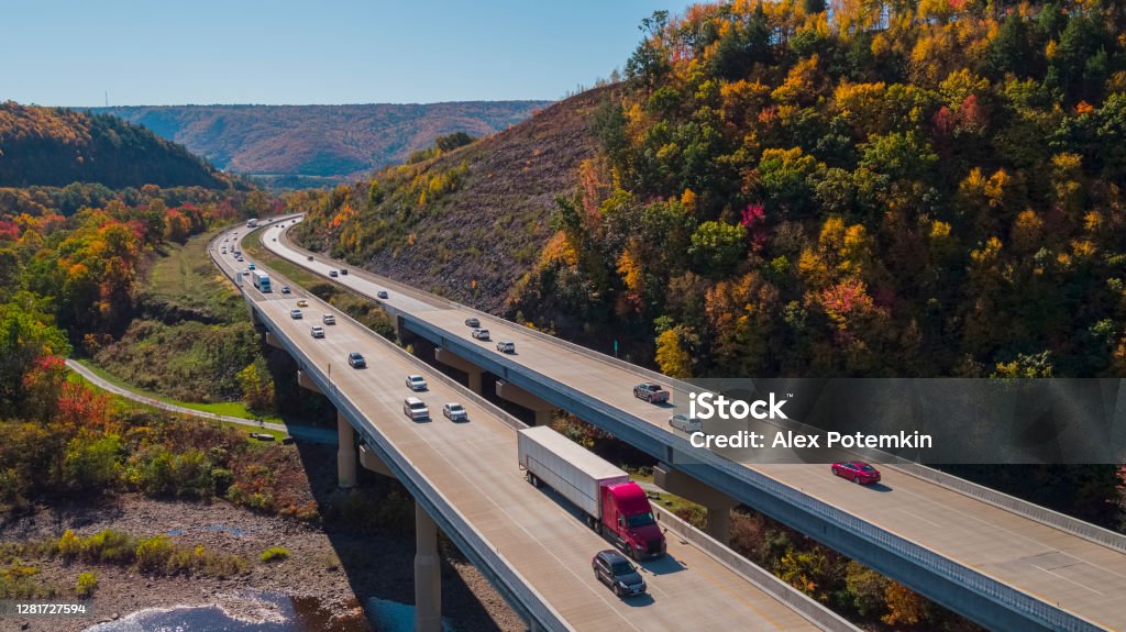 Scenic aerial view of the high bridge at the Pennsylvania Turnpike lying between mountains in Appalachian on a sunny day in fall. The high bridge at the Pennsylvania Turnpike on the sunny spring day. Lehigh Valley, Poconos region, Pennsylvania, USA. Truck Stock Photo