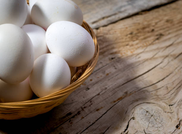 istock Organic eggs in a wicker basket on wooden table, close-up. Copy space for text. 1281736835