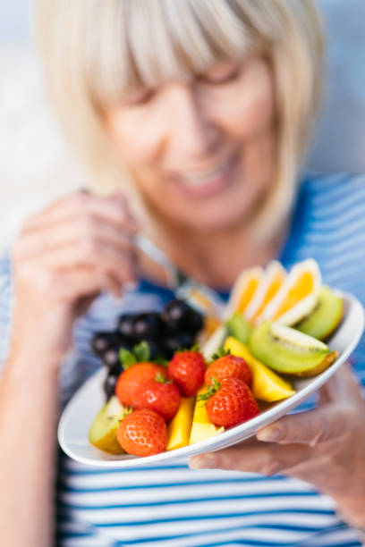 istock Attractive senior woman with fruit lunch 1281750010