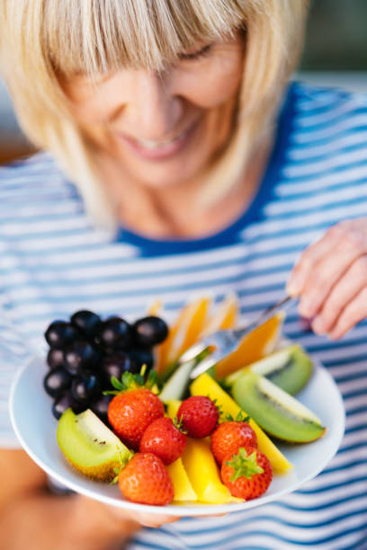 istock Attractive senior woman with fruit lunch 1281750851