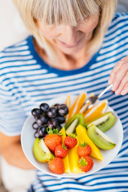 istock Attractive senior woman with fruit lunch 1281752101
